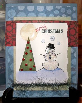 Joy2Christmas Digital Snowman Scene
I set this scene up in PSE 8.0 and used the tree and snowman as brushes. I added some shadows and embossed effect to the snowflakes and had the Merry Christmas print in color. I colored everything else with copics after printing, added stickles and one of those clear adhesive dimensional circle things. Mounted it all on some various coordinating patterned paper, tossed some sparkly fibers on. 
Keywords: digital